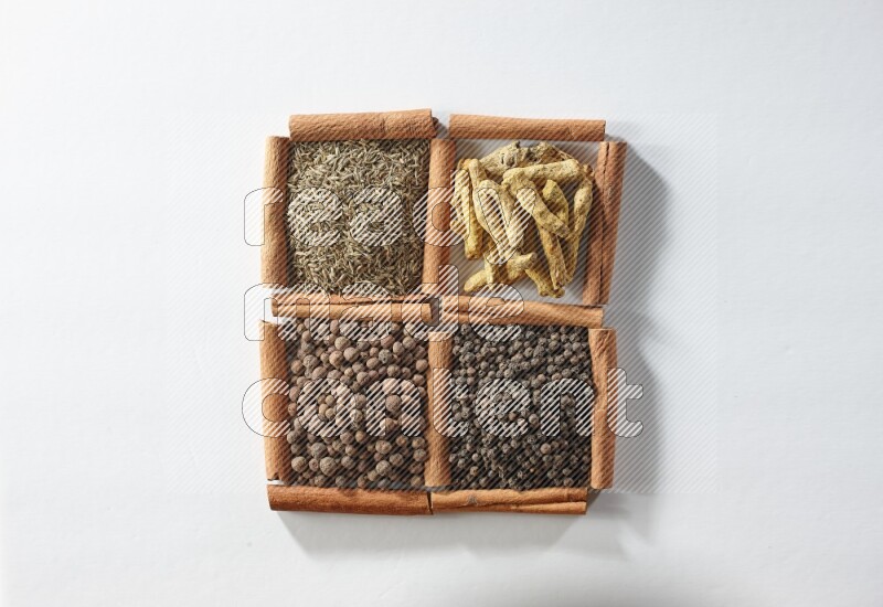 4 squares of cinnamon sticks full of cumin, turmeric fingers, allspice and black pepper on white flooring