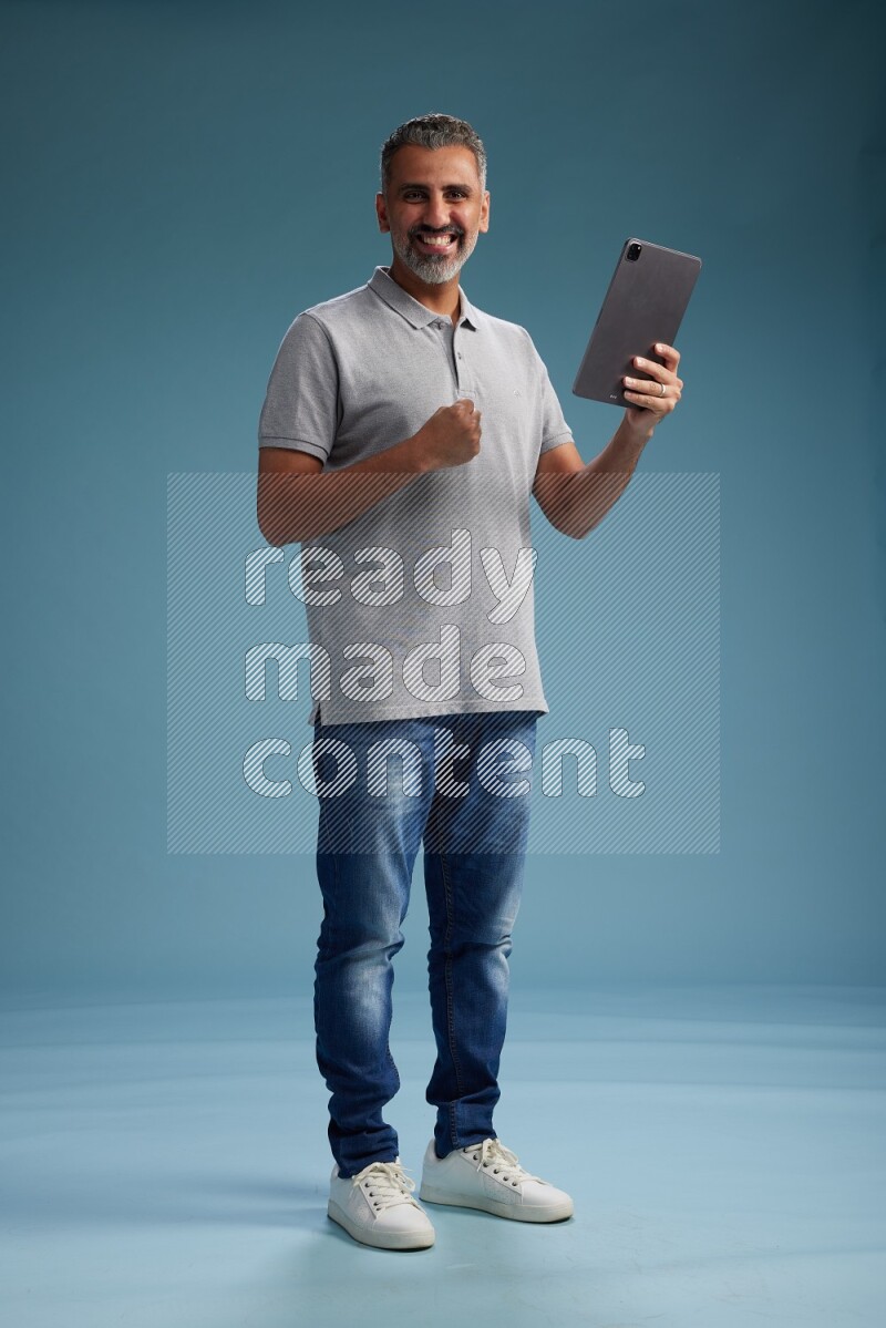 Man Standing working on tablet on blue background