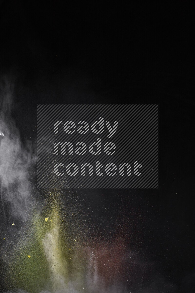 A side view of multicolored powder explosion on black background