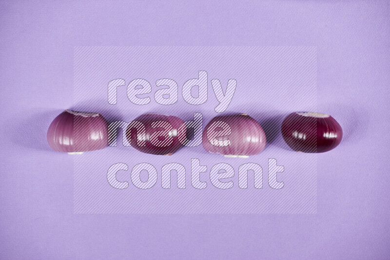 Halves red onions on a purple background