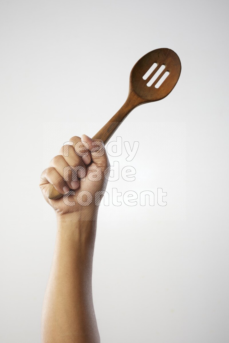 Male Hand Holding Wooden colander spoon  on white background
