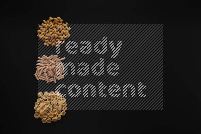 Different pasta types in 3 bunches on black background