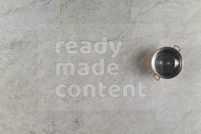 A small copper pot on grey marble background