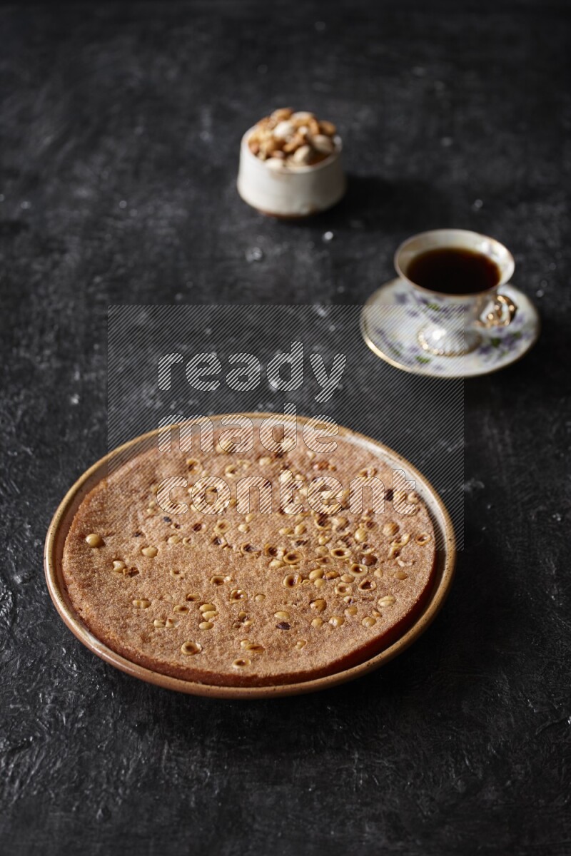 Basbousa with nuts and tea in a dark setup