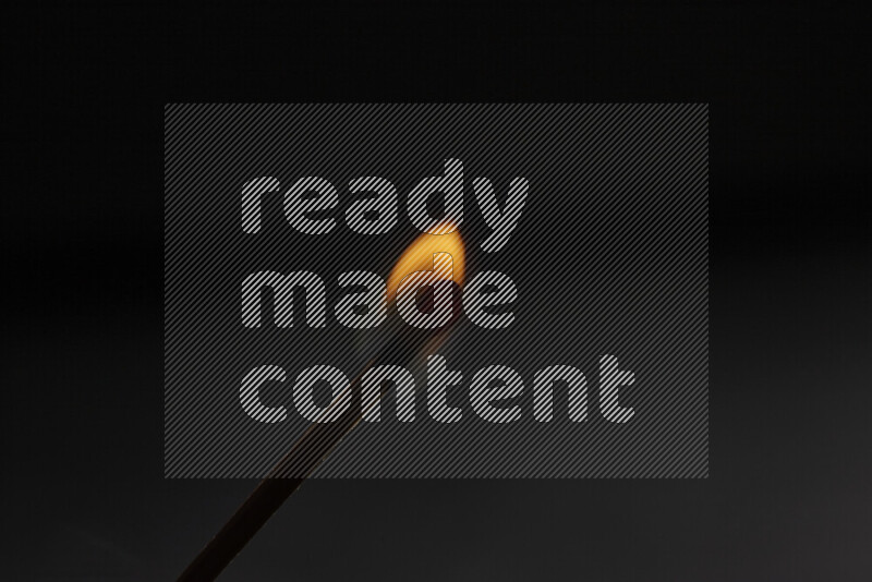 عود ثقاب مشتعل على خلفية داكنة