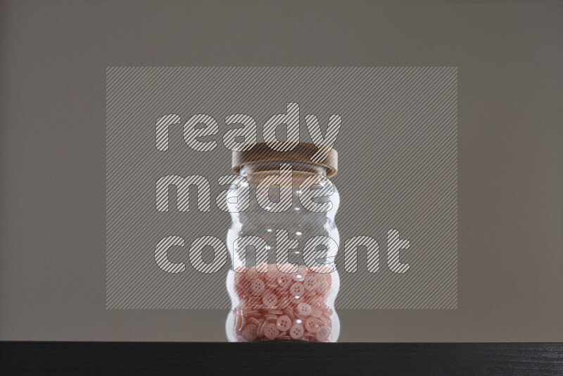 Buttons in a glass jar on black background