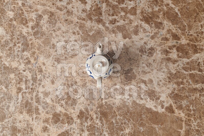 A pottery teapot on beige marble background
