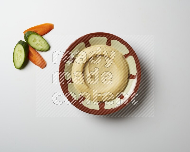 Plain hummus in a traditional plate on a white background