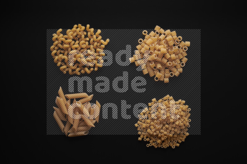 Different pasta types in bunches on black background