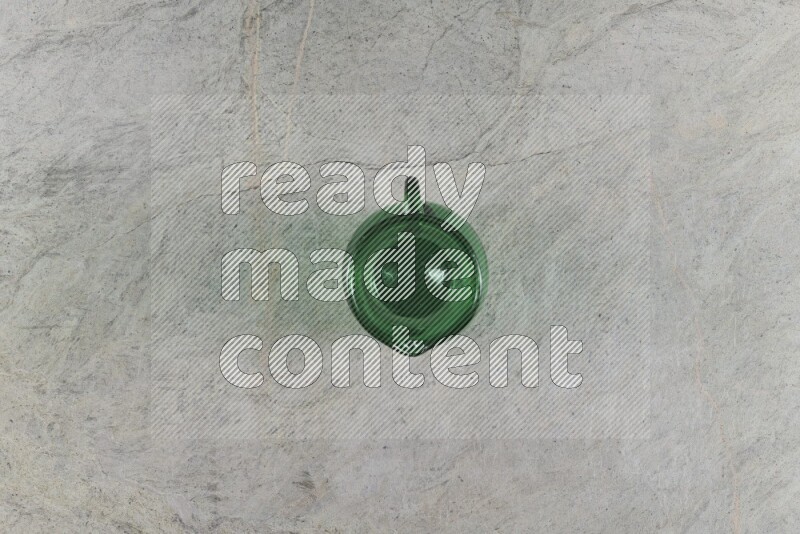 A colored glass jug on grey marble background