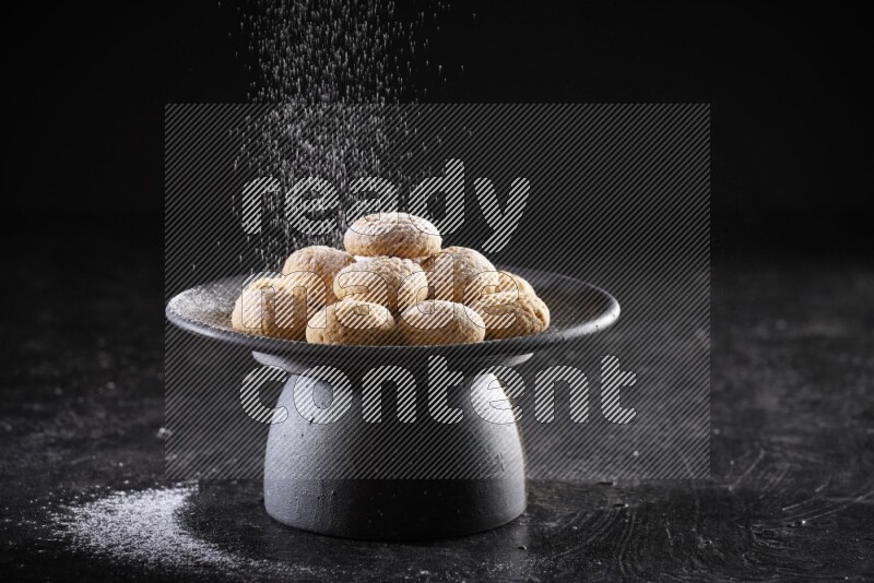 Kahk on a serving plate on a black background