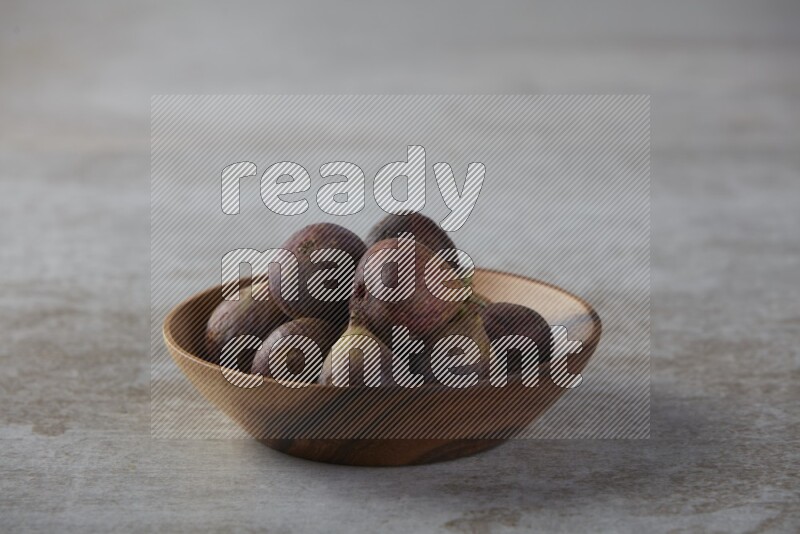 Fresh figs in a bowl on textured grey background
