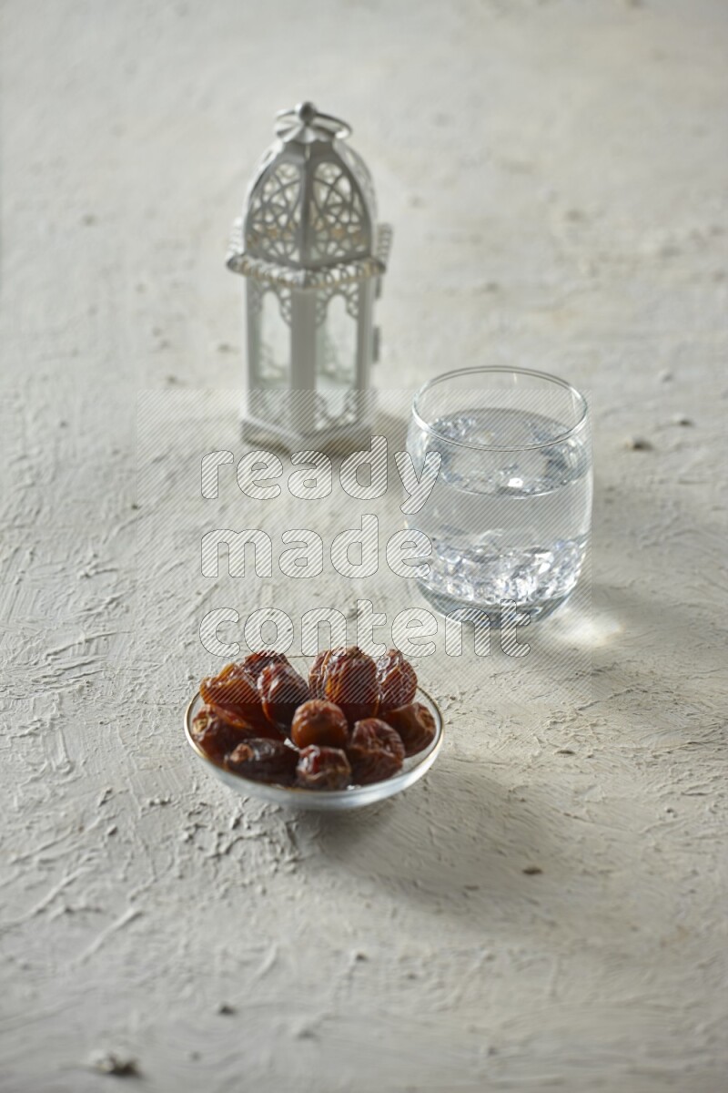 A white lantern with different drinks, dates, nuts, prayer beads and quran on white background