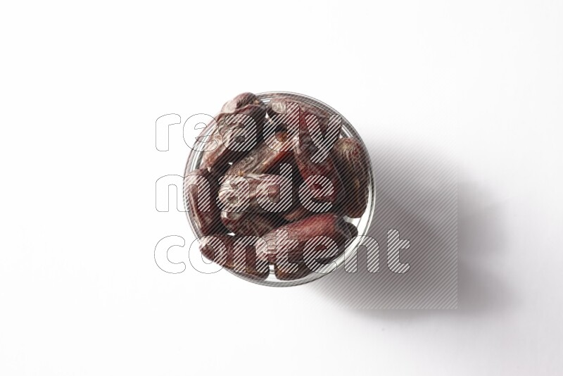 Dates in a glass bowl on white background