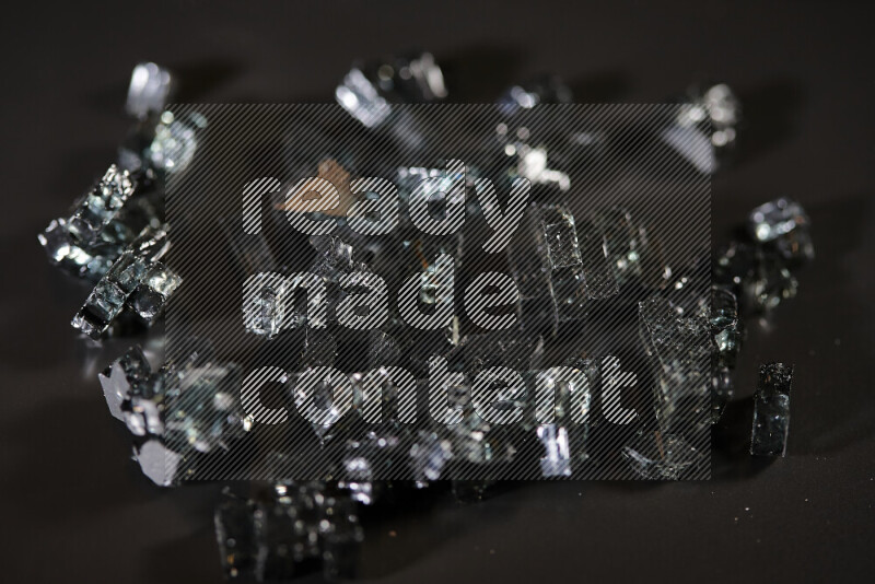 Transparent black fragments of glass scattered on a black background