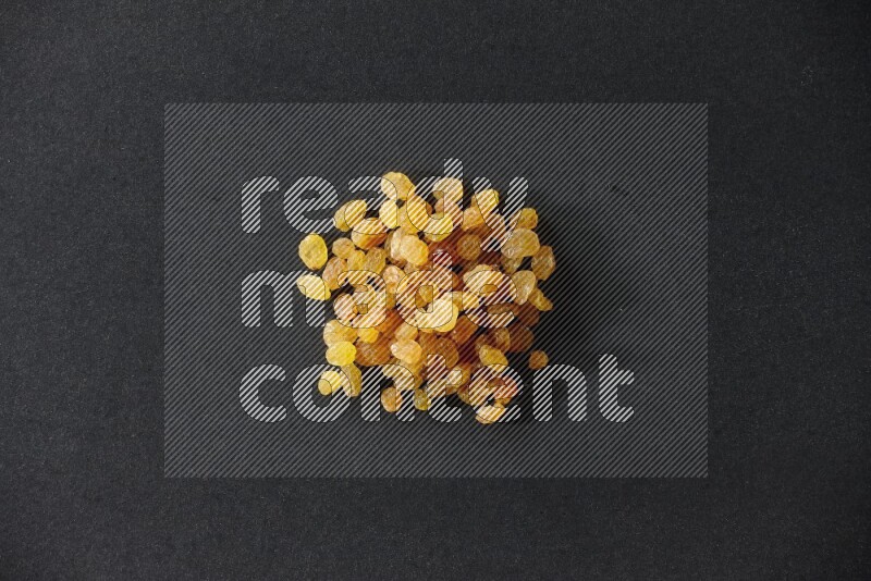 Yellow raisins isolated on a black background in different angles