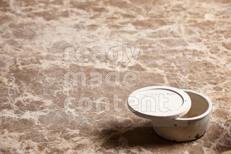 A white pottery bowl on beige marble background