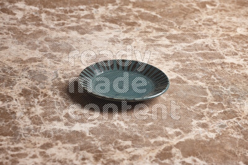 A multicolored pottery plate on beige marble background