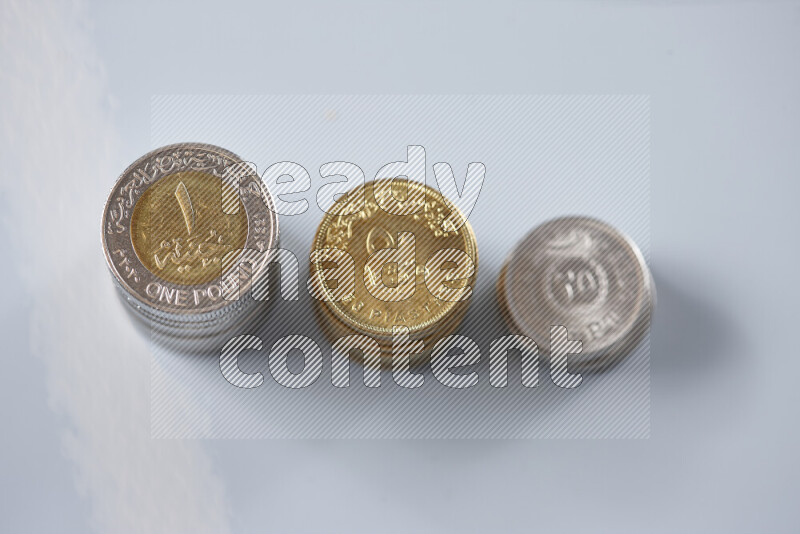 A close-up of scattered mixed Egyptian coins such as One pound, 50 and 25 piasters on grey background