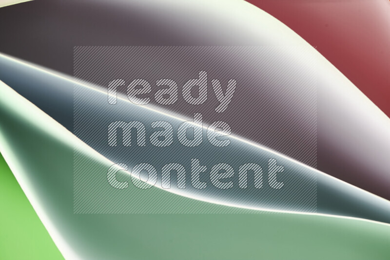This image showcases an abstract paper art composition with paper curves in green and red gradients created by colored light