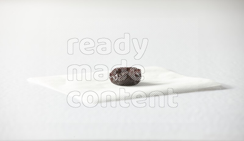 A dried plum on a piece of paper on a white background in different angles