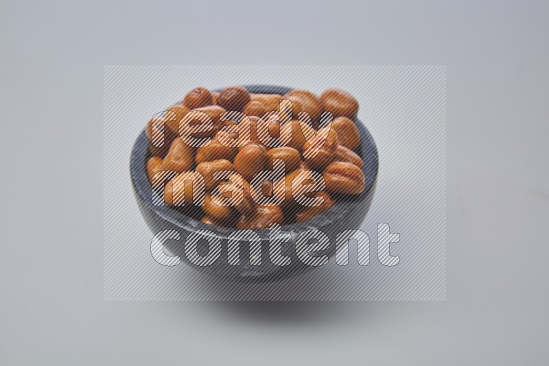 Close up shot of cooked fava beans (foul) in a container on white background