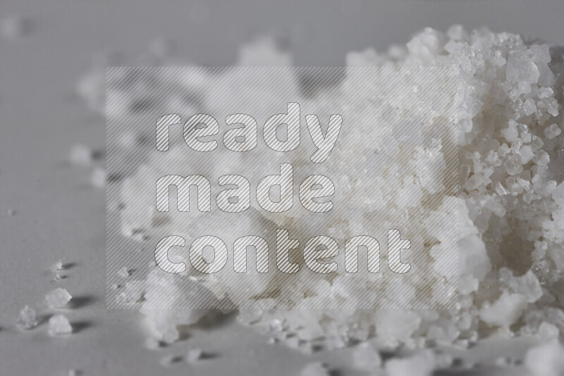 A bunch of coarse sea salt crystals on white background
