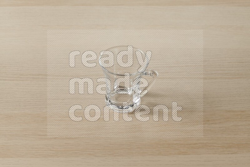 An empty glass cup on light wooden background