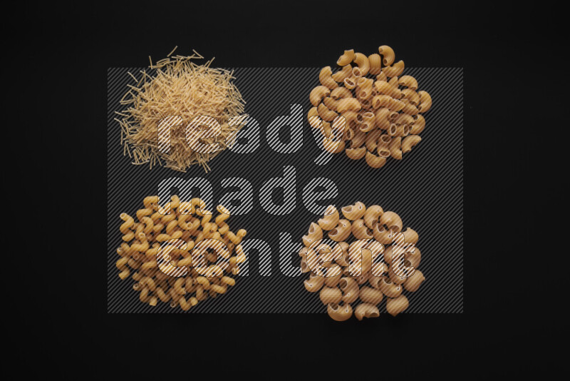 Different pasta types in bunches on black background
