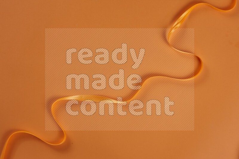 An orange collection of sewing and tailoring tools arranged on a orange background