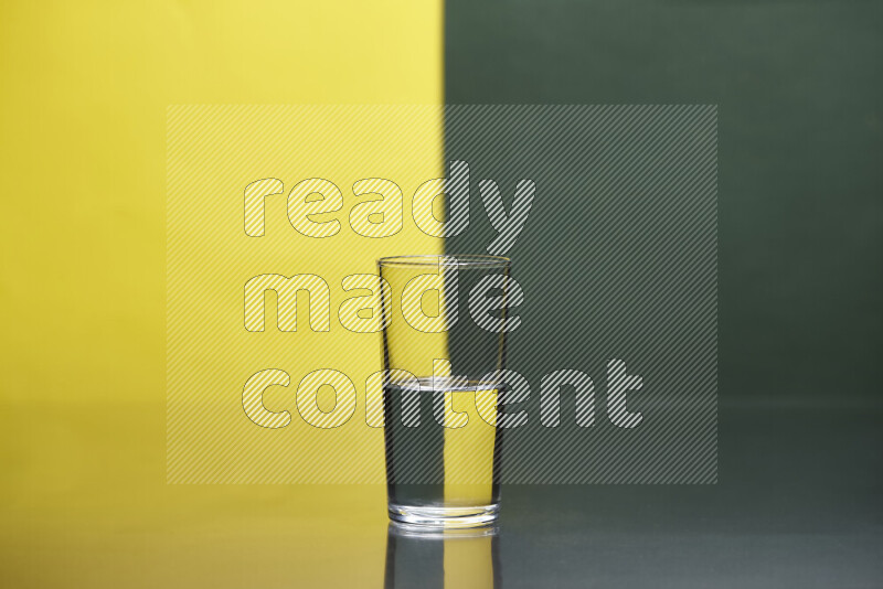 The image features a clear glassware filled with water, set against yellow and dark green background