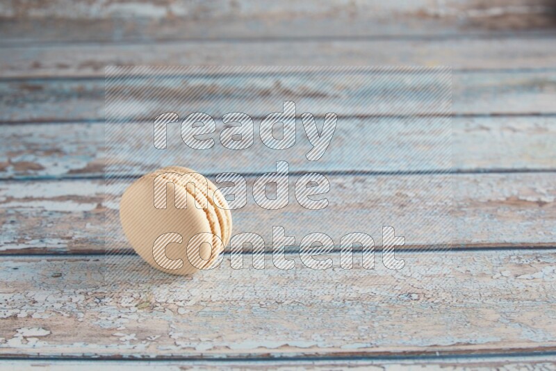 45º Shot of White Caramel fleur de sel macaron on light blue wooden background