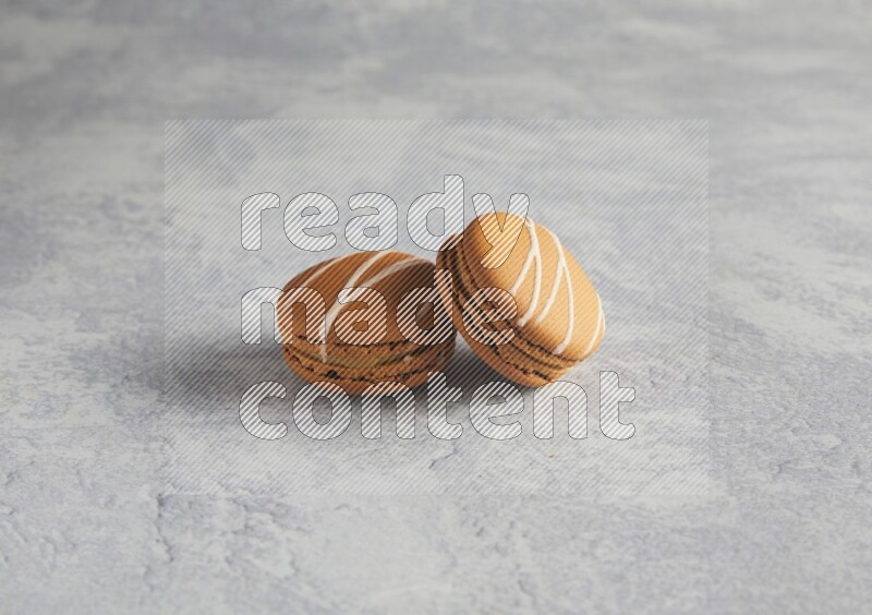 45º Shot of two Brown Irish Cream macarons  on white  marble background