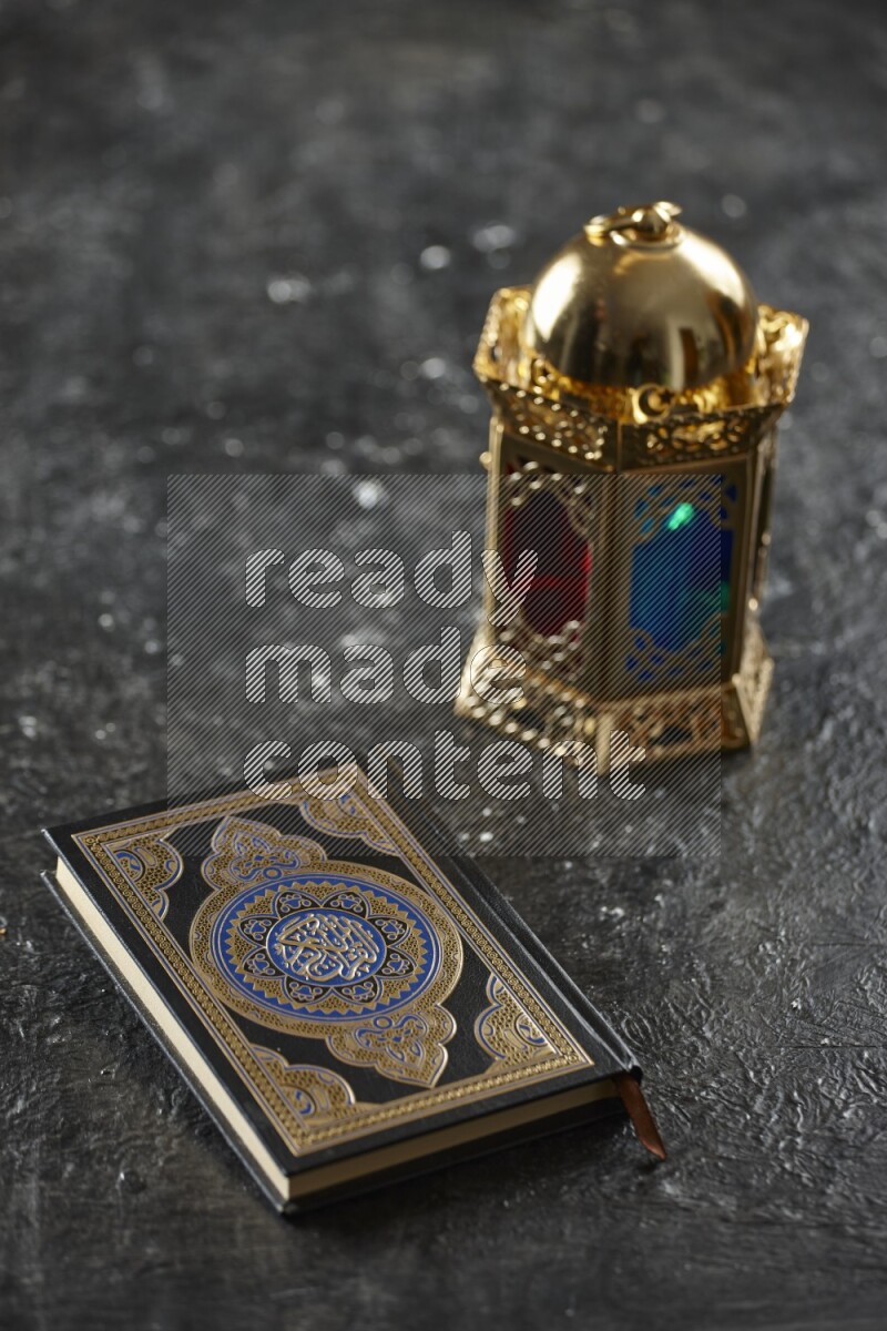 A golden lantern with different drinks, dates, nuts, prayer beads and quran on textured black background