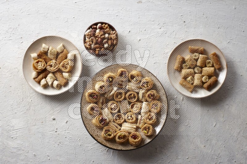Oriental sweets in pottery plates with nuts in a light setup