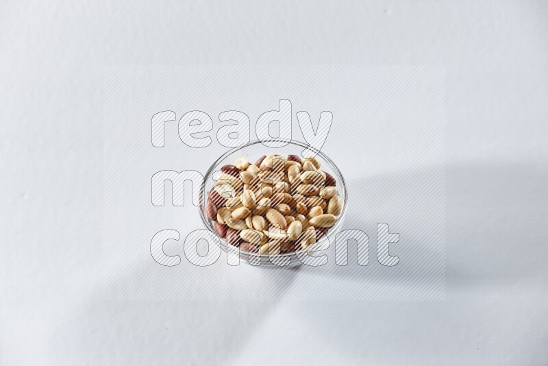 A glass bowl full of peeled peanuts on a white background in different angles