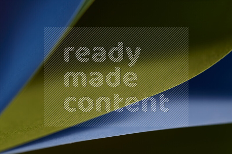 An abstract art showing blue and green paper sheets arranged in an overlapping curves