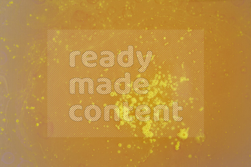 The image captures a dramatic splatter of yellow paint over a white backdrop