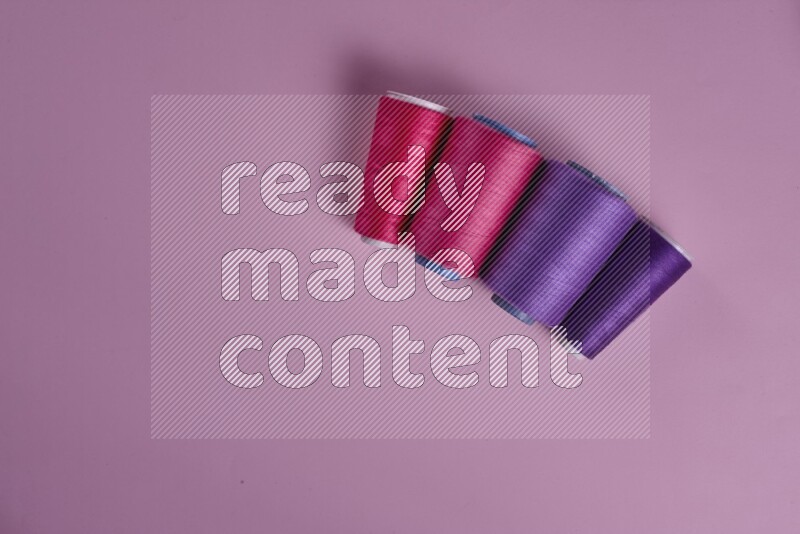 A purple and pink collection of sewing and tailoring tools arranged on a pink background