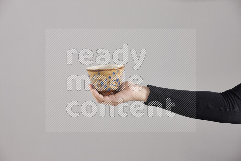 A woman in black abaya holding different pottery essentials in different positions