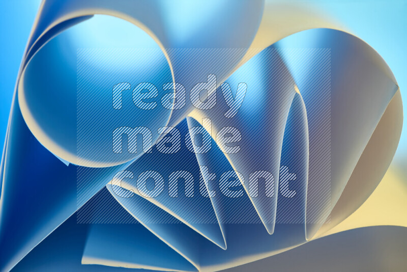 An artistic display of paper folds creating a harmonious blend of geometric shapes, highlighted by soft lighting in blue and warm tones