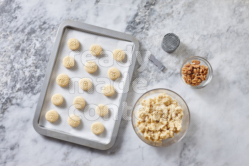 Kahk step by step with its ingredients ghee, sugar, flour, sesame, yeast, water and kahk flavor on grey marble background