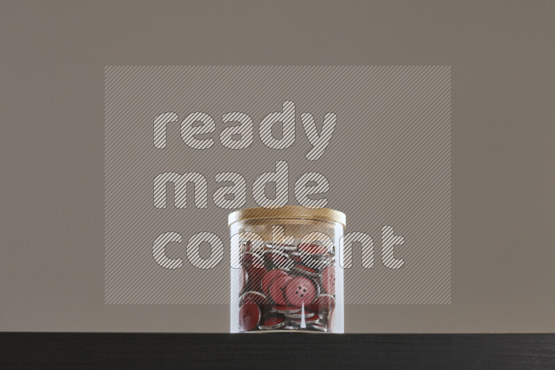 أزرار متنوعة في وعاء زجاجي علي خلفية سوداء