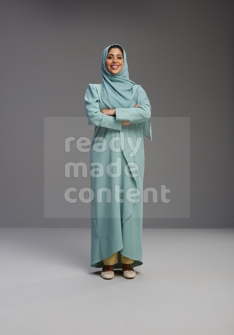 Saudi Woman wearing Abaya standing with crossed arms on Gray background