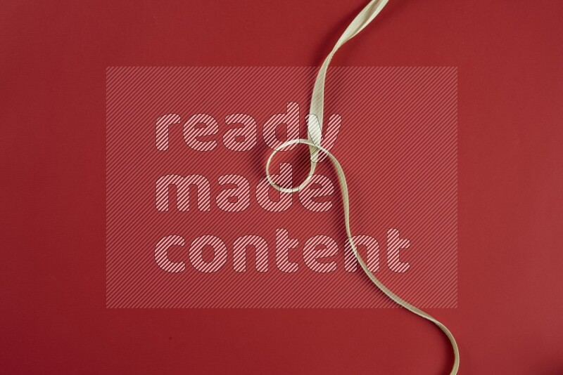 مجموعة من أدوات الخياطة والتفصيل خضراء وحمراء اللون على خلفية حمراء