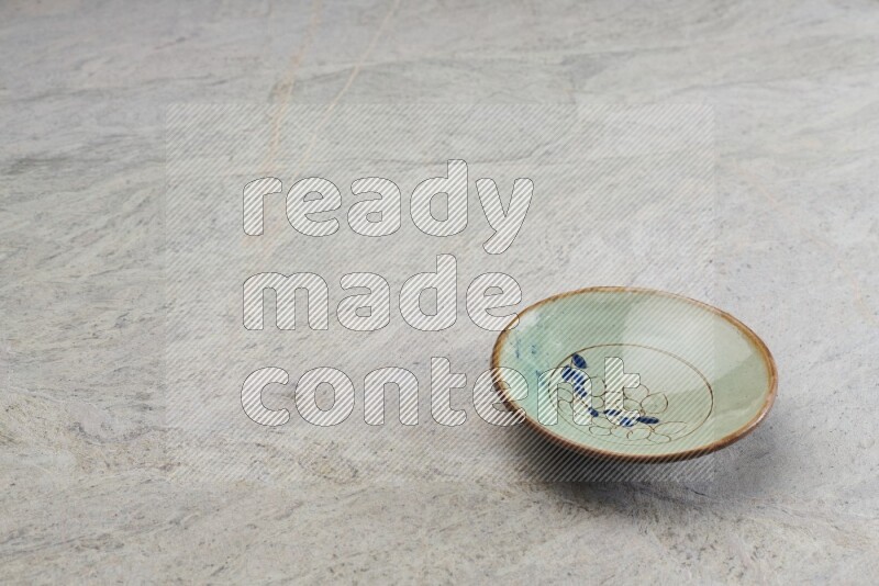 A decorative pottery plate on grey marble background