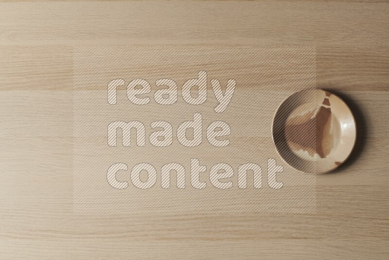 A multicolored pottery plate on light wooden background