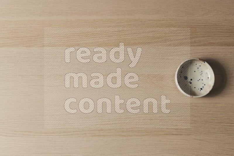 وعاء فخاري متعدد الألوان على خلفية خشبية فاتحة