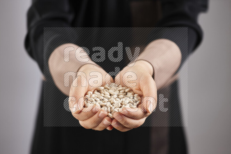 Woman in abaya holding different kinds of legumes in different positions