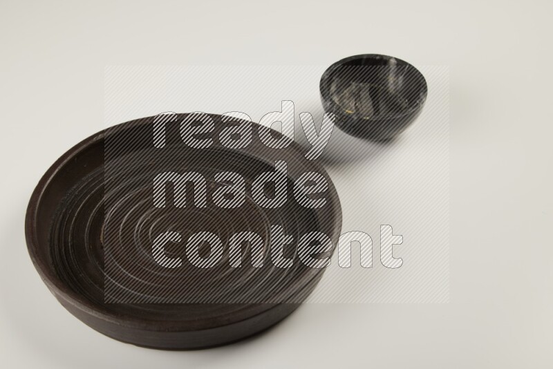 black pottery plate and black bowls on white background